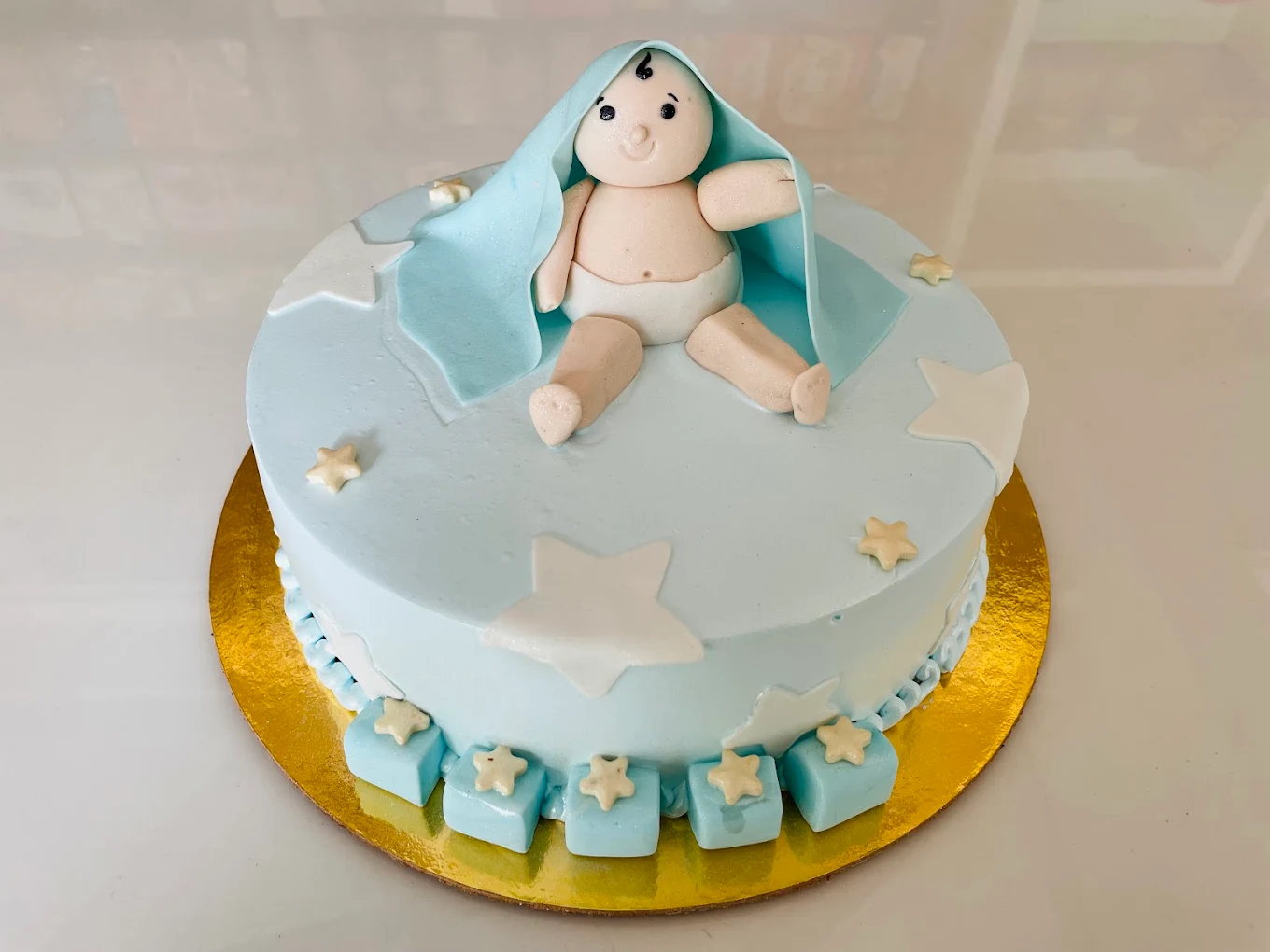 Baby shower cake with fondant baby figure and stars