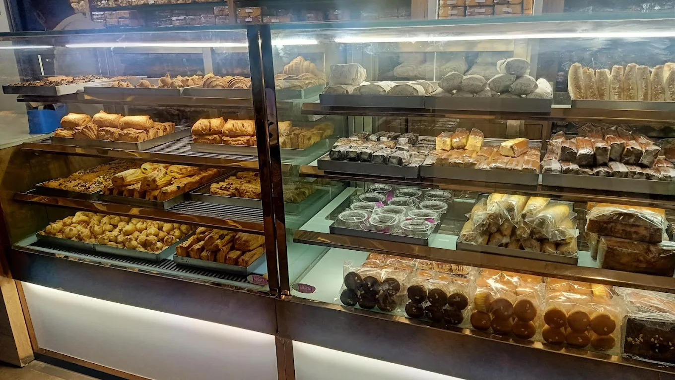 Glass display showcasing pastries, muffins and cakes