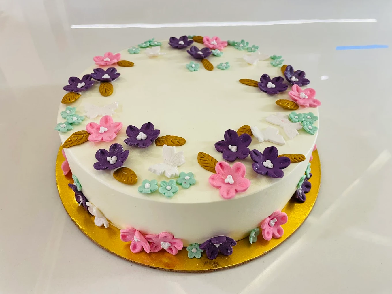 Elegant fondant flower and butterfly decorated cake