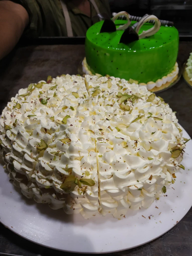 Pistachio cream cake with green kiwi cake in background
